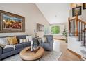 Comfortable living room featuring hardwood floors, a vaulted ceiling, and large picture window at 6836 Edgewood Way, Highlands Ranch, CO 80130