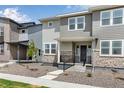 Attractive two-story townhome featuring stone accents, covered entry, and professionally maintained landscape at 1422 Hudson Pl, Longmont, CO 80501