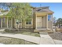 Home exterior featuring a covered front porch, manicured lawn, and tasteful, neutral color palette at 11153 W 17Th Ave # 101, Lakewood, CO 80215