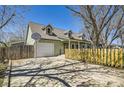 Charming two-story home with a driveway basketball hoop and a beautiful, newly built yellow fence at 1065 6Th St, Berthoud, CO 80513
