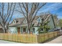 View of a charming house featuring dormer windows, a manicured lawn, and wooden fence at 1065 6Th St, Berthoud, CO 80513