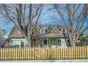Charming home with a wood picket fence, mature trees, and well-maintained landscaping at 1065 6Th St, Berthoud, CO 80513