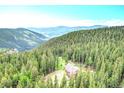 Stunning aerial view of a secluded home nestled among lush green trees and rolling mountains at 1176 Raven Ridge Rd, Idaho Springs, CO 80452