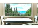 Indoor dining area with a large window framing a stunning view of the surrounding forest and distant mountains at 1176 Raven Ridge Rd, Idaho Springs, CO 80452
