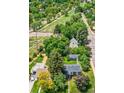 Aerial view showcases the home nestled among mature trees with a neighborhood path visible at 1901 S Adams St, Denver, CO 80210
