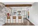 Beautiful kitchen with white cabinetry, an island with bar seating, stone accent wall, and stainless steel appliances at 3437 N Jackson St, Denver, CO 80205