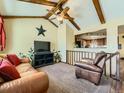 Cozy living room with vaulted ceilings, exposed beams, and open view to the kitchen at 438 N 11Th Ave, Brighton, CO 80601