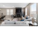 Bright living room features a cozy fireplace and large windows that offer plenty of natural light at 17233 W 93Rd Pl, Arvada, CO 80007