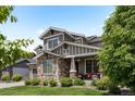 Charming home with a stone facade, covered porch, and lush landscaping, creating an inviting curb appeal at 20293 E Shady Ridge Rd, Parker, CO 80134