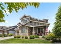 Attractive gray home with stone accents, a covered porch, and a neatly landscaped front yard at 20293 E Shady Ridge Rd, Parker, CO 80134