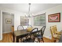 Inviting dining room with hardwood floors, a modern chandelier, and a window at 6235 E 6Th Avenue Pkwy, Denver, CO 80220