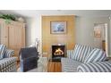 Cozy living room with a modern fireplace, wood floors, and stylish striped furniture at 6235 E 6Th Avenue Pkwy, Denver, CO 80220