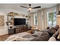 Cozy living room with plush seating, large windows, decorative shelving, and a ceiling fan at 12920 W 24Th Pl, Golden, CO 80401