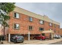 Well-maintained brick apartment building with covered parking and mature trees at 155 S Pennsylvania St # 101, Denver, CO 80209