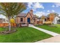 Charming brick home featuring mature trees, a manicured lawn, and a welcoming entrance at 4710 W 32Nd Ave, Denver, CO 80212