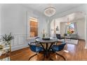 Elegant dining room with hardwood floors, a round table with blue chairs, and a chandelier at 568 Galapago St, Denver, CO 80204