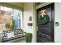 Inviting front porch with a swing, dark wood front door with wreath at 568 Galapago St, Denver, CO 80204