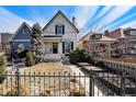 Charming two-story home with a well-manicured front yard and a black wrought iron fence at 568 Galapago St, Denver, CO 80204