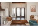 Foyer features dark wood floors, modern light fixture, white marble fireplace and a desert landscape photo at 7341 E Jarvis Pl, Denver, CO 80237