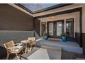 Front entrance with double doors, wood chairs, blue planters, black brick, and a 'Welcome' mat at 7341 E Jarvis Pl, Denver, CO 80237