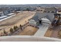 Aerial view of a gray home with a three-car garage and a large lot in a residential area at 1839 Pinion Wing Cir, Castle Rock, CO 80108
