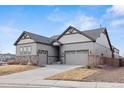 Charming home showcasing stone accents, a three-car garage, and fresh landscaping at 1839 Pinion Wing Cir, Castle Rock, CO 80108