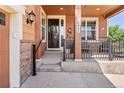 Inviting front porch with decorative wreaths and a seating area, perfect for relaxing outdoors at 14805 Quince Way, Thornton, CO 80602