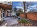 Cozy outdoor patio with brick surround, stone ground covering, string lights and exterior seating at 2500 S York St # 102, Denver, CO 80210