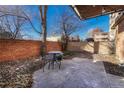 Private patio with brick surround, stone ground covering, and furnished with table and chairs at 2500 S York St # 102, Denver, CO 80210