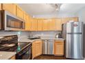 Efficient kitchen features stainless steel appliances and light wood cabinets at 8653 E Dry Creek Rd # 1114, Englewood, CO 80112