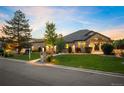 Beautiful brick home with a manicured lawn, mature trees, and a welcoming front porch at 13087 W 27Th Ln, Golden, CO 80401