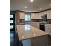 Modern kitchen features a quartz countertop island, stainless steel appliances and elegant tiled backsplash at 795 Vivian Ct, Lakewood, CO 80401