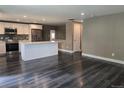 Open-concept space with sleek, hardwood floors, connecting the living area to a modern kitchen with a central island at 795 Vivian Ct, Lakewood, CO 80401