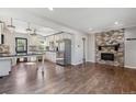 Open-concept living room showcasing hardwood floors, a brick fireplace, and seamless flow to the kitchen at 765 Iola St, Aurora, CO 80010