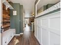 Inviting entryway with coat hooks, a hall bench, and a large decorative mirror across from the front door at 6826 S Holland Way, Littleton, CO 80128