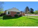 Lawn with lush grass and brick-lined walkway leading to a charming brick home at 2301 E Yale Ave, Denver, CO 80210