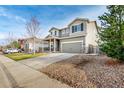 Two-story home featuring a covered front porch, two-car garage and low maintenance landscaping at 574 Solano Dr, Brighton, CO 80603