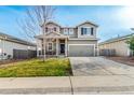 Two-story home featuring a covered front porch, an attached two-car garage and landscaping at 574 Solano Dr, Brighton, CO 80603