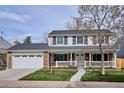 Inviting two-story home with brick facade, white trim, a covered porch, and green lawn at 7343 S Ivy Way, Centennial, CO 80112