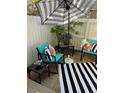Cozy patio area with stylish outdoor furniture, striped umbrella, and decorative accents at 4663 S Fraser Ct # C, Aurora, CO 80015