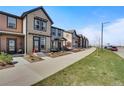 Exterior view of the home on a street with similar-style townhomes and landscaped yards at 11440 E Martin Luther King Jr Blvd, Denver, CO 80238