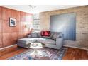 Inviting living room boasts hardwood floors, brick accent wall, modern art, and comfortable seating at 3050 S Marion St, Englewood, CO 80113