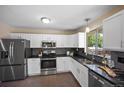 Modern kitchen with stainless steel appliances, white cabinets, and dark countertops at 9346 Flower St, Broomfield, CO 80021