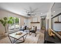 Spacious living room featuring a ceiling fan, large window, and stylish decor at 9346 Flower St, Broomfield, CO 80021