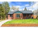 Beautiful brick home featuring a well-kept lawn, complemented by mature trees at 2120 N Poplar St, Denver, CO 80207