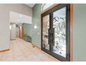 Elegant foyer featuring a custom front door, tile flooring, and stylish lighting at 1988 Lake Dr, Larkspur, CO 80118