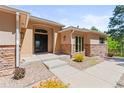 Inviting front entrance with stone accents, a modern door, and manicured landscaping at 1988 Lake Dr, Larkspur, CO 80118