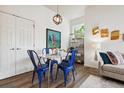 Bright dining area featuring hardwood floors, a modern light fixture, and a square marble table with blue chairs at 2708 Syracuse St # 109, Denver, CO 80238