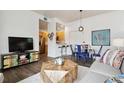 Cozy living room with a unique wooden coffee table and an open layout flowing into the kitchen at 2708 Syracuse St # 109, Denver, CO 80238