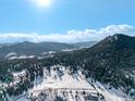 Stunning aerial view of a sprawling property, with mountain range in the background at 8537 S Doubleheader Hwy, Morrison, CO 80465